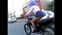 Hündin geht auf einem Motorrad und zeigt ihren Schwanz