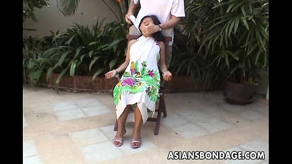 Teen asiatique ligotée et menottée sur une chaise