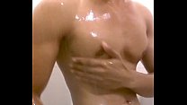 Красивый мужчина принимает душ и демонстрирует свое тело