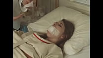 ベッド病院に縛られた 衣テープの口のかなりブルネット