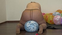 Une grosse fille en collants s'assoit sur des ballons et pisse