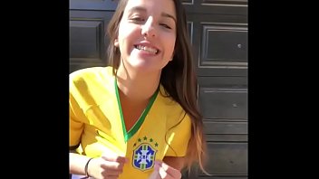 Bambina molto sexy con pantaloncini corti che indossa la maglia della Nazionale brasiliana