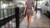 Femme chaude marchant en robe serrée remuant le butin sexy