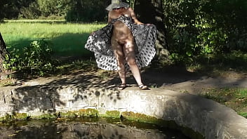 Poilue mature nue dans un parc public