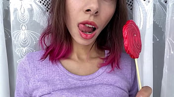 Freche Stiefschwester lutscht ein Bonbon und zeigt ihre lange, heiße, sexy Zunge