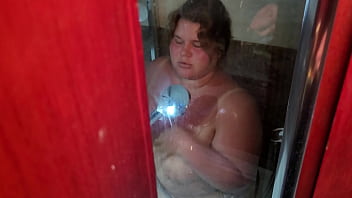 Una gorda bronceada con un hermoso rostro chupa una polla caliente en la ducha del limpiador de habitaciones y él se corre masivamente en su cara y boca