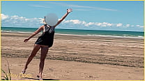 Une femme joue au football nue sur une plage publique habillée