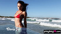 Das dünne, ganz natürliche ukrainische Babe Gloria Sol zieht sich draußen am Strand aus