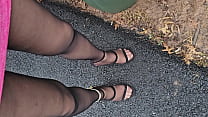 Renee` wearing black pantyhose, rainbow anklet, high fuck me heels, pink sparkley mini dress in public, outdoors