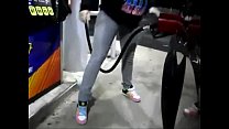 garota desesperada fazendo xixi no jeans enquanto bombeia gasolina